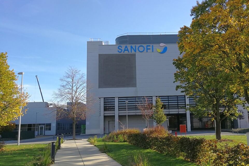 A modern industrial building with the Sanofi logo