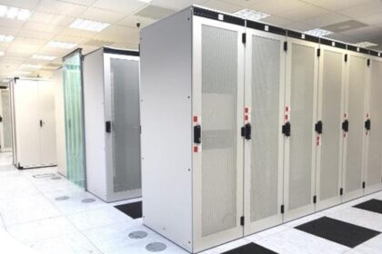 A room with rows of white server racks in a data center.