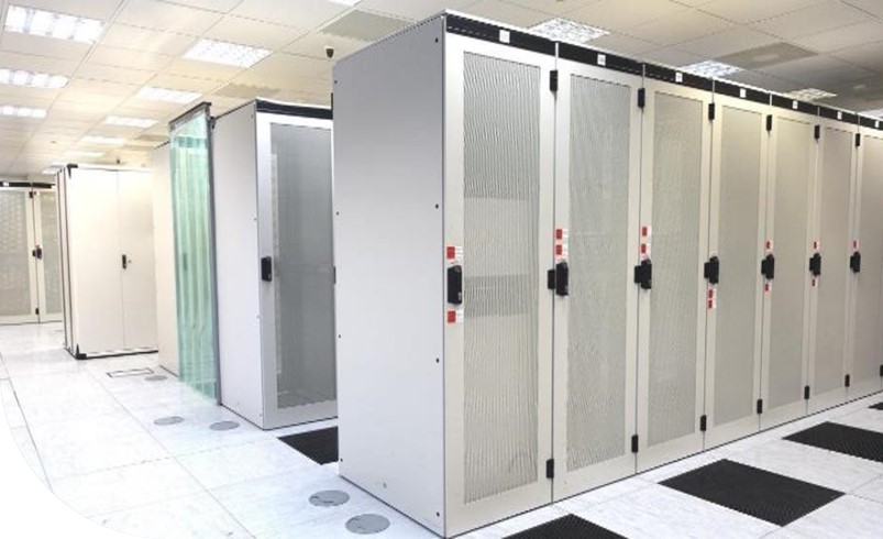 A room with rows of white server racks in a data center.