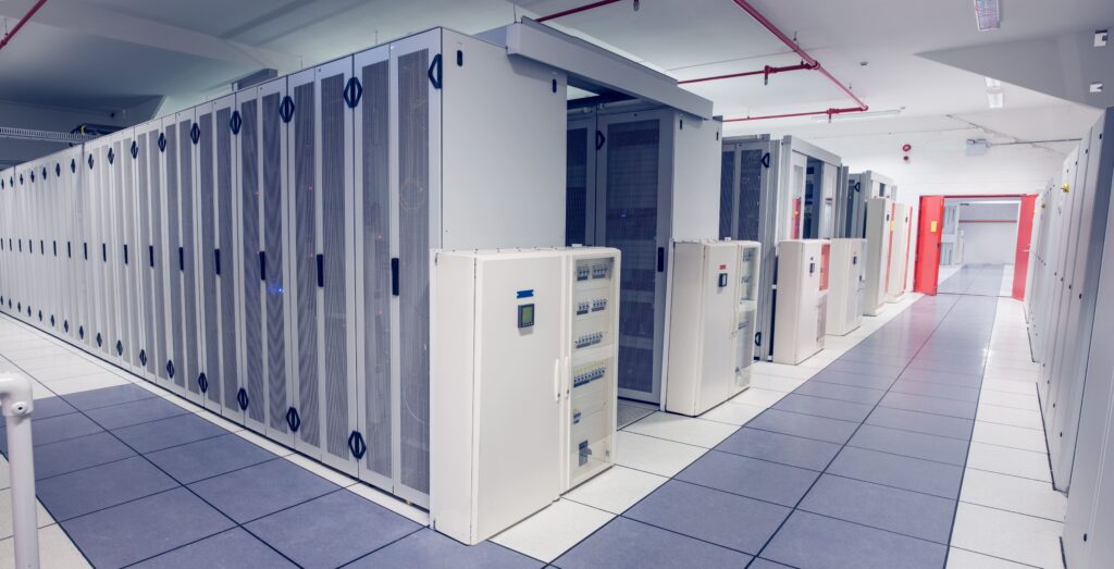 A room with rows of server racks in a data center.