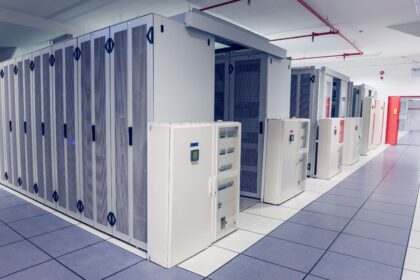 A room with rows of server racks in a data center.