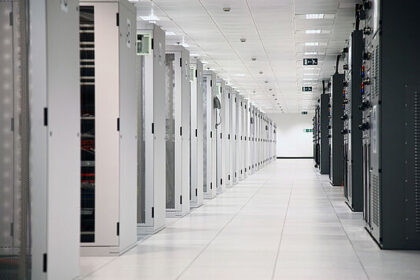 A room with rows of server racks in a data center.