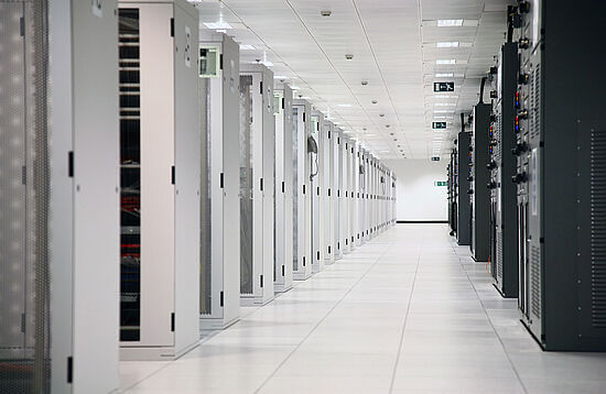 A room with rows of server racks in a data center.