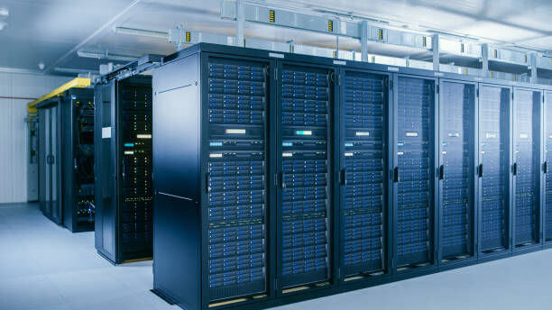 A room with rows of server racks in a data center.