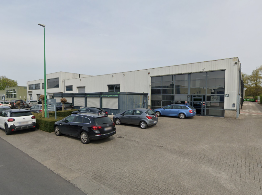 A view of a commercial building with several parked cars in front.