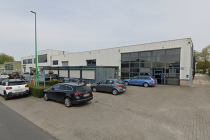 A view of a commercial building with several parked cars in front.