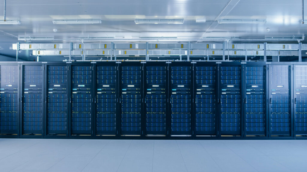 A room with rows of server racks in a data center.