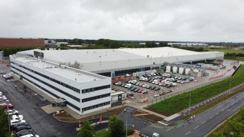 An aerial view of a large industrial facility with parking lots and surrounding roads.