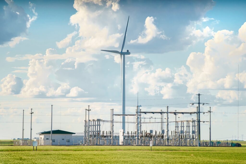 A wind turbine standing next to an electrical substation