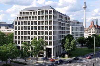 A large office building in Berlin with the Fernsehturm tower in the background.