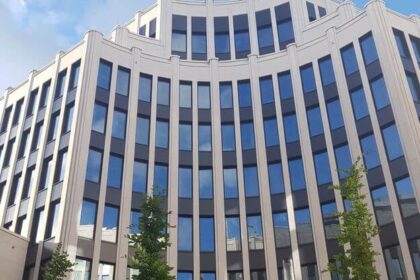 A modern office building with tall windows and a curved facade