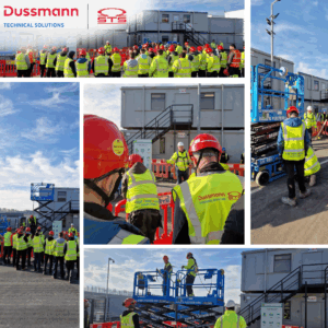 The photo collage depicts various activities and scenes associated with Dussmann Technical Solutions at what appears to be a construction or industrial site. It shows groups of workers in high-visibility vests and hard hats participating in what could be safety briefings or site inductions near modular buildings. The presence of boom lifts suggests work at height is being conducted or demonstrated. Overall, the images convey a sense of activity and focus on safety within the work environment of Dussmann Technical Solutions.